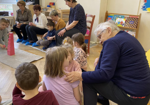 Zdjęcie przedstawia kobietę rozmawiającą z dziewczynką.