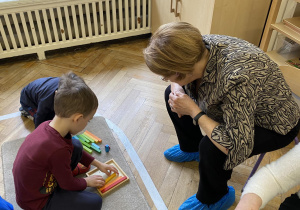 Zdjęcie przedstawia kobietę i chłopca przy matematycznej układance.