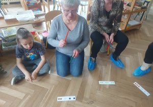 Zdjęcie przedstawia kobietę wystukującą rytm patyczkami.
