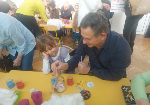 Na zdjęciu dziewczynka z dziadkiem wykonuje kosmos w słoiku