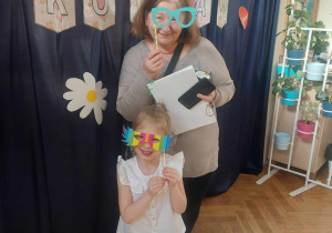 Babcia z wnuczką podczas zdjęcia obie trzymają rekwizyty