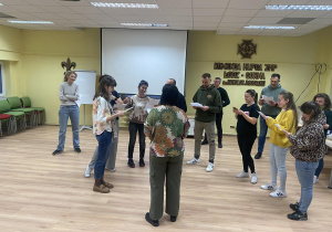 Zdjęcie przedstawia grupę rodziców podczas próby.