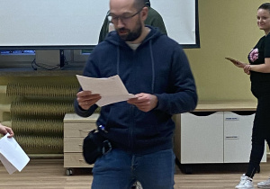 Zdjęcie przedstawia mężczyznę czytającego swoją rolę.