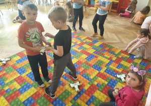 Zdjęcie przedstawia grupę dzieci wykonujących zadanie projektowe