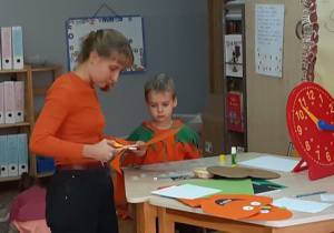 Zdjęcie przedstawia wolontariuszkę i chłopca podczas wykonywania pracy plastycznej.