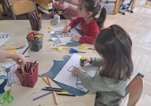 Zdjęcie przedstawia dzieci wykonujące kolorowe skarpety z papieru.