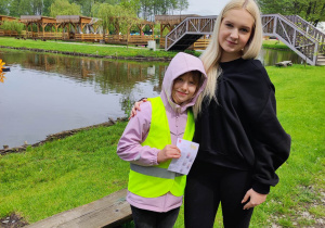 Zdjęcie przedstawia pracownicę Dobronianki oraz dziewczynkę, która trzyma w ręku ulotkę.