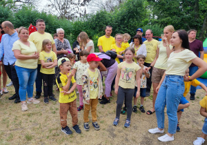 Zdjęcie przedstawia grupę rodziców i dzieci, oraz nauczycielki w żółtych koszulkach.