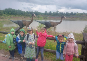 Na zdjęciu widać dzieci, które zwiedzają park dinozaurów
