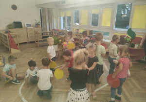 Zdjęcie przedstawia dzieci trzymające w rękach kolorowe koła. Dzieci biorą udział w zabawie muzyczno- ruchowej.