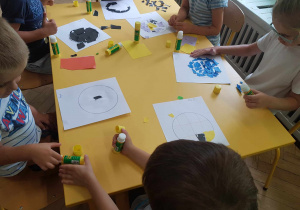 Dzieci robiące kompozycje z wydzieranych elementów.