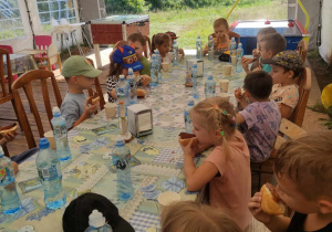 Zdjęcie przedstawia dzieci siedzące przy stole i spożywające posiłek.
