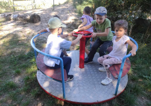 Zdjęcie przedstawia dzieci korzystające z karuzeli.