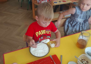 Na zdjęciu widać dzieci podczas przygotowywania deseru