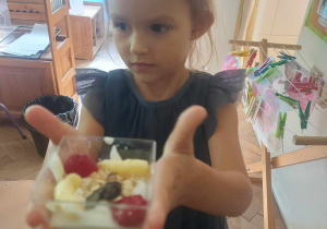 Zdjecie przedstawia dziewczynkę, która prezentuje swój deser