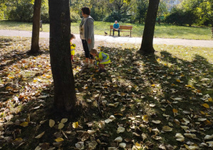 Na zdjęciu widzimy jak dziewczynka siega po liść.