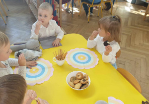 Na zdjęciu widzimy dzieci, które jedą słodki poczęstunek po wspólnej zabawie.
