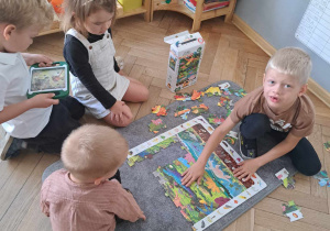 Zdjęcie przedstawia dzieci układające puzzle.