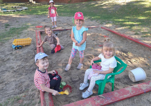 Zdjęcie przedstawia dzieci bawiące się w piaskownicy.