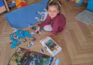 Zdjęcie przedstawia dziewczynkę układającą puzzle.