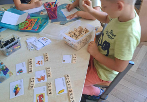 Zdjęcie przedstawia chłopca układającego wyrazy.