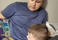 Na zdjęciu widać mężczyznę z małym chłopcem podczas wieczornego czytania