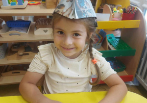 Zdjęcie przedstawia dziewczynkę z czapka na głowie