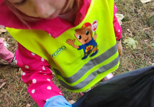 dziecko zbiera śmieci w parku