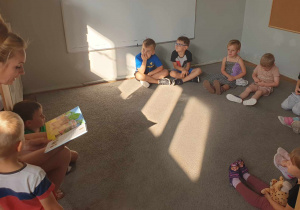 Na zdjęciu widzimy mamę jednego z chłopców z naszej grupy, która czyta dzieciom bajkę.
