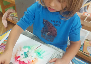 Na zdjęciu jest chłopiec tworzący liścia, bawiący się kolorami