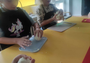 Dzieci ugniatają ciasto na kluski