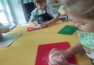 Dzieci ugniatają ciasto na kluski
