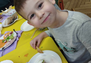 Na zdjęciu widzimy uśmiechniętego chłopca, który zrobił własną kanapkę.