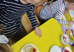 Na zdjęciu widzimy dziewczynkę, która przed sobą na talerzyku ma zrobioną kanapkę.