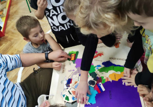 Dzieci pracujące z drewnianą mapą Europy.