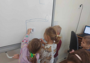 Na zdjęciu widać dzieci, które rysują obraz liter dla dzieci, które ich nie znają