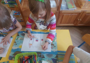 Zdjęcie przedstawia dziewczynkę, która rysuje zamek w Gnieźnie