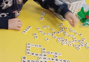 Chłopiec buduje słowa z liter