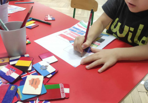 Chłopiec rysuje flagi państw europejskich