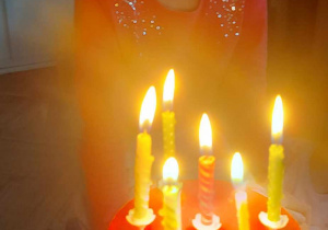 Zdjęcie przedstawia Oliwkę, która dmucha urodzinowe świeczki