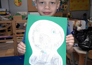 Zdjęcie przedstawia chłopca trzymającego w ręku narysowany przez siebie portret Janusza Korczaka.