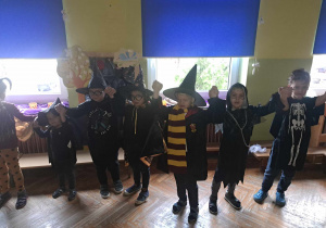 Zdjęcie przedstawia dzieci trzymające się za podniesione do góry ręce.