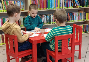 Pracujące przedszkolaki przy stoliku.