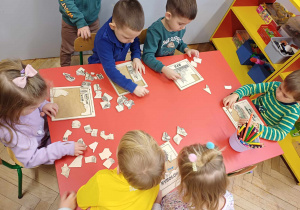 Dzieci układające puzzle z poznanymi do tej pory zwierzętami.