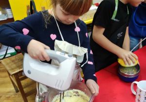 Dziecko miksuje składniki ciasta mikserem