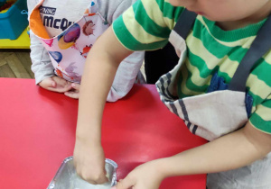 Dziecko smaruje foremkę masłem