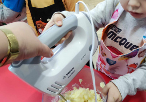 Dziecko miksuje składniki ciasta mikserem