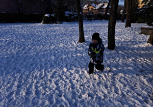 Zdjęcie przedstawia chłopca biegnącego po śniegu.