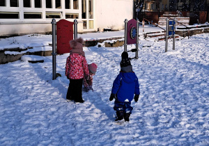 Zdjęcie przedstawia dzieci bawiące się na śniegu.