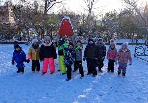 Zdjęcie przedstawia grupę dzieci stojących na śniegu.